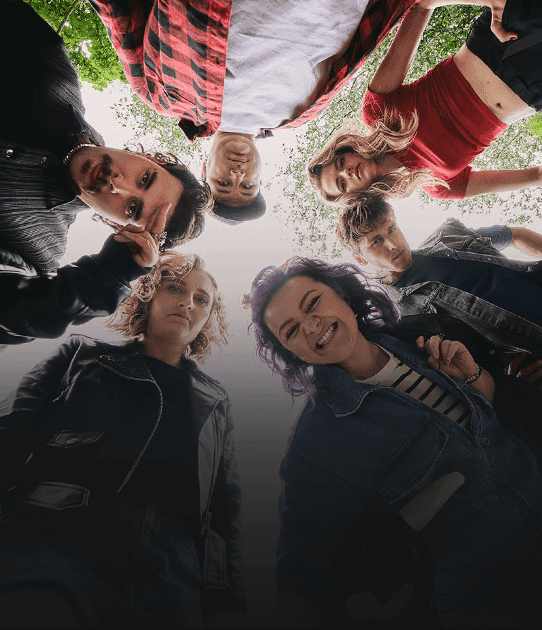 Sześć młodych osób patrzy w dół w stronę obiektywu; niektórzy są poważni, inni uśmiechnięci