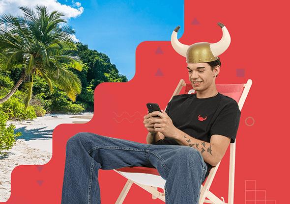 A boy is sitting with a phone on a deckchair, with a beach in the background